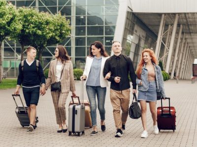 happy-positive-young-people-with-luggage-outdoor-near-airport_108945-1016